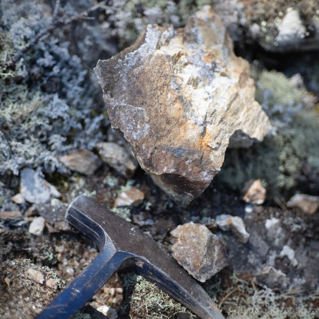 Kőzetminta és geológuskalapács közelről