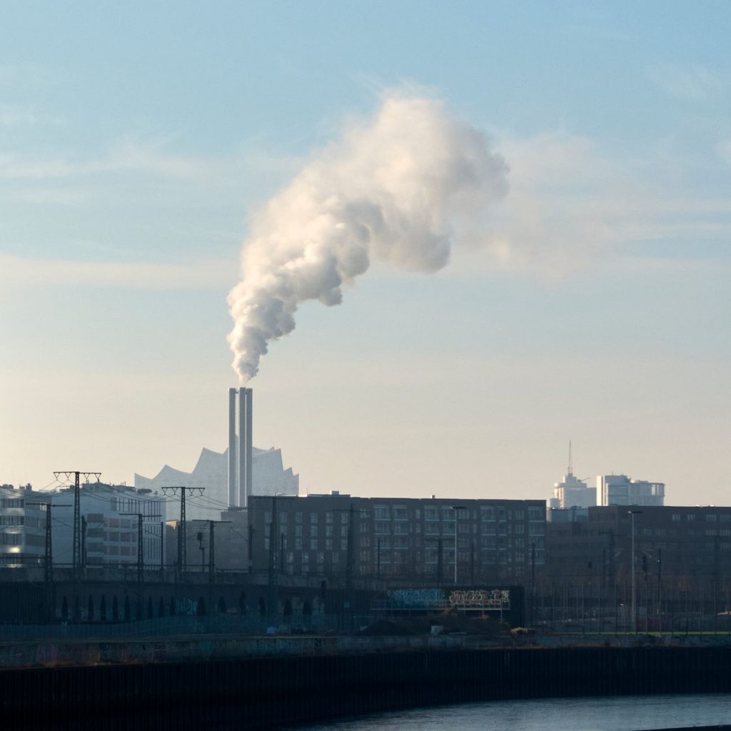 Füstölő kémény a városi látkép felett