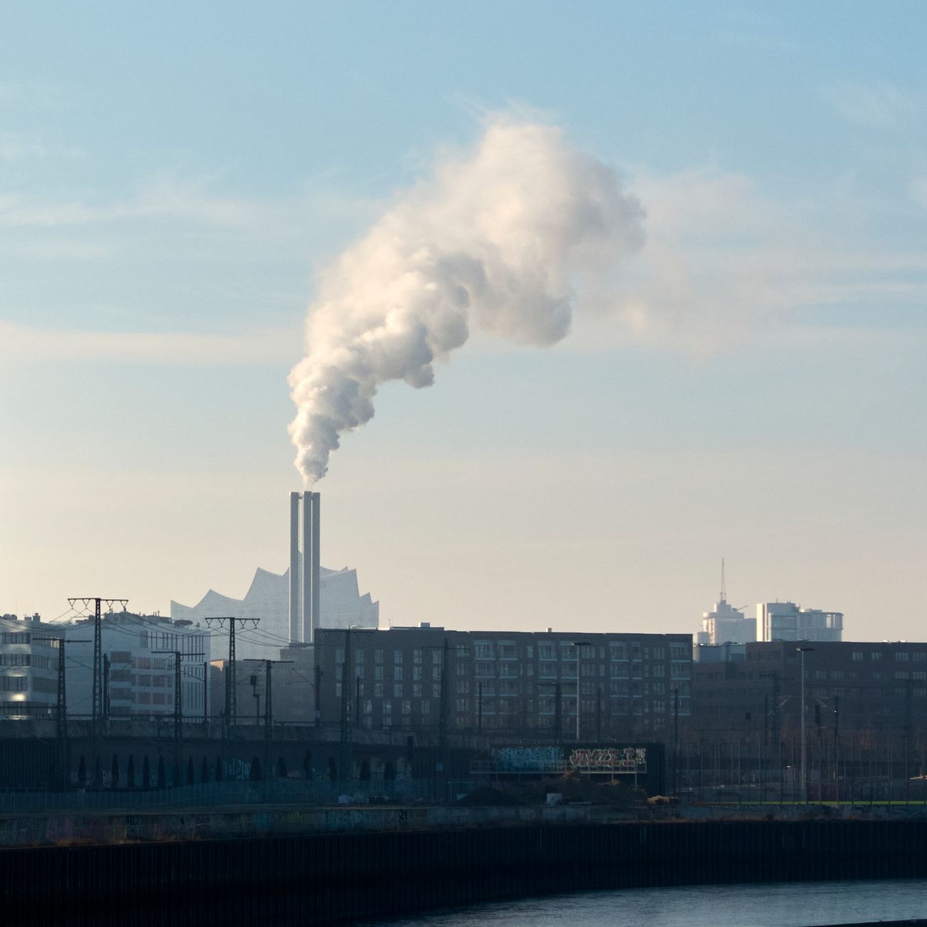 Füstölő ipari kémény a városi látkép felett